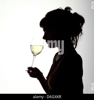 Portrait Silhouette d'une jeune femme buvant un verre de vin blanc Banque D'Images