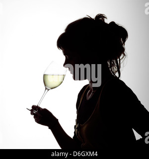 Portrait Silhouette d'une jeune femme buvant un verre de vin blanc Banque D'Images