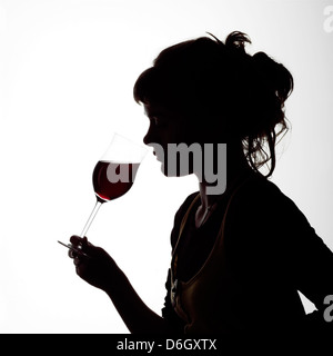 Portrait Silhouette d'une jeune femme buvant un verre de vin rouge Banque D'Images