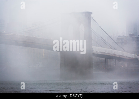 Le brouillard roulant sur le pont de Brooklyn Banque D'Images