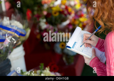 Prendre des notes en boutique de fleuriste Banque D'Images