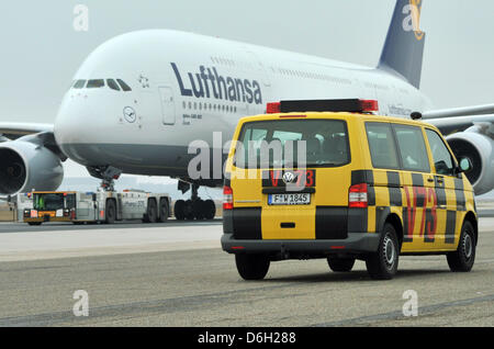 Un soi-disant suivez moi véhicule passé un Airbus A-380 avion Lufthansa à l'aéroport Rhin-Main de Francfort, Allemagne, 28 février 2012. L'Union européenne l'organisation de la grève à l'aéroport de Francfort est la mobilisation de la circulation aérienne le mercredi, 29 février 2012, pour forcer une mise à l'arrêt complet de l'Allemagne s la hub. Les contrôleurs aériens GdF union a été appelant les travailleurs du Banque D'Images