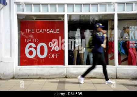 Cambridge, UK. 18 avril 2013. Shoppers à Cambridge UK note de vente panneaux dans une vitrine. L'Office national des statistiques ont fait état d'une baisse des ventes au détail de 0,7  % en mars par rapport à février 2013 au Royaume-Uni. Les ventes dans les magasins de la rue haute sont soupçonnés d'avoir été réduit en raison des récentes intempéries. Credit : Julian Eales/Alamy Live News Banque D'Images