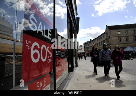 Cambridge, UK. 18 avril 2013. Shoppers à Cambridge UK note de vente panneaux dans une vitrine. L'Office national des statistiques ont fait état d'une baisse des ventes au détail de 0,7  % en mars par rapport à février 2013 au Royaume-Uni. Les ventes dans les magasins de la rue haute sont soupçonnés d'avoir été réduit en raison des récentes intempéries. Credit : Julian Eales/Alamy Live News Banque D'Images