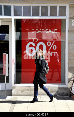 Cambridge, UK. 18 avril 2013. Shoppers à Cambridge UK note de vente panneaux dans une vitrine. L'Office national des statistiques ont fait état d'une baisse des ventes au détail de 0,7  % en mars par rapport à février 2013 au Royaume-Uni. Les ventes dans les magasins de la rue haute sont soupçonnés d'avoir été réduit en raison des récentes intempéries. Credit : Julian Eales/Alamy Live News Banque D'Images