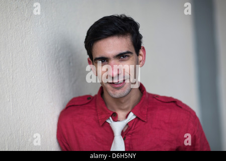 Smiling man leaning on wall Banque D'Images