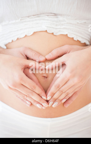 Couple holding pregnant woman's abdomen Banque D'Images