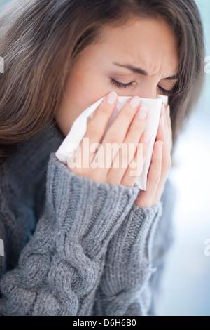 Woman blowing son nez Banque D'Images