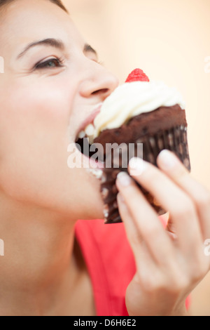 Femme mangeant un cup cake Banque D'Images