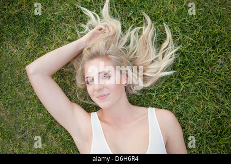 Smiling woman laying in grass Banque D'Images