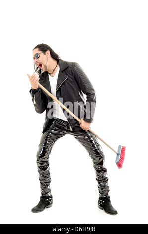 Man Rocking Out avec broom Banque D'Images