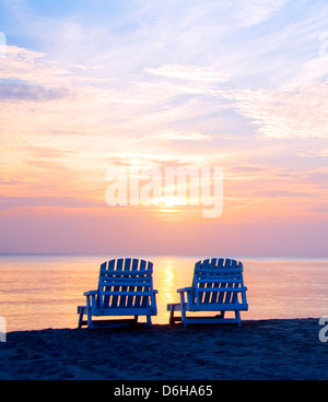 Coucher du soleil, le Centre de pique-nique plage avec chaises longues et des bateaux en mer des Caraïbes distance Big Corn Island Nicaragua Amérique Centrale Banque D'Images