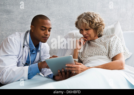 Doctor showing digital tablet to patient in hospital Banque D'Images