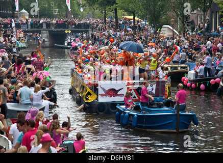 La parade de la Gay Pride dans un canal bordé de monde avec des personnes et des bateaux à Amsterdam, Hollande. Banque D'Images
