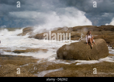 Fille sur rock et surf sur des rochers près de la Poloma à Rocha Uruguay Banque D'Images