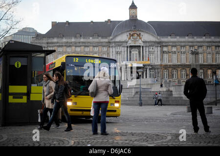 Les piétons attendez un bus sur la Place Saint-Lambert à Liège, Belgique, 08 mars 2012. Le Palais des Princes-Évêques, l'actuel palais de justice, est représentée dans l'arrière-plan. Photo : Marius Becker Banque D'Images