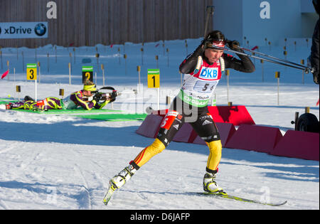 Les biathlètes allemand Andrea Henkel quitte le tir avant française Marie Dorin Habert au cours de la 4x6 km à l'épreuve de relais des Championnats du monde de Biathlon 2012 à Chiemgau Arena à Ruhpolding, Allemagne, 10 mars 2012. Photo : Peter Kneffel Banque D'Images