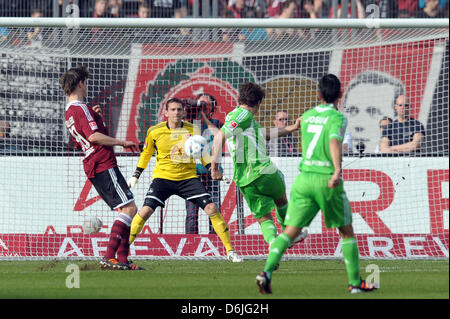 Le gardien Raphael Schaefer (2-L) ne peut pas sauver la balle par Wolfsburg's Patrick Helmes (3-R) à la 1-1 au cours de la Bundesliga match de foot entre 1. FC Nuremberg et VfL Wolfsburg dans le easyCredit-Stadium à Nuremberg, Allemagne, 17 mars 2012. Photo : DAVID EBENER (ATTENTION : EMBARGO SUR LES CONDITIONS ! Le LDF permet la poursuite de l'utilisation des images dans l'IPTV, m Banque D'Images