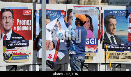 Un homme met en place des affiches électorales des candidats à l'élection présidentielle française de Marseille, France, 28 mars 2012. Les élections présidentielles en France commence le 22 avril 2012. Bulletin final est prévue pour le 06 mai 2012. Photo : Andreas Gebert Banque D'Images