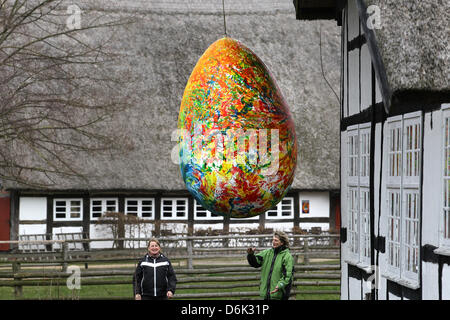 Deux femmes se tenir sous un mètre 2,20 Grand Oeuf de Pâques géant au musée en plein air Klockenhagen, Allemagne, 30 mars 2012. L'œuf est partie d'une exposition spéciale "l'Œuf et la coupe". Le musée en plein air ouvre ses granges, étables et maisons pour la nouvelle saison le 01 avril 2012. Photo : Bernd Wuestneck Banque D'Images