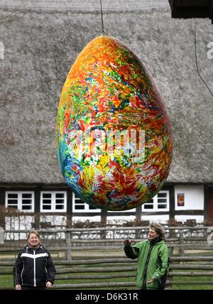 Deux femmes se tenir sous un mètre 2,20 Grand Oeuf de Pâques géant au musée en plein air Klockenhagen, Allemagne, 30 mars 2012. L'œuf est partie d'une exposition spéciale "l'Œuf et la coupe". Le musée en plein air ouvre ses granges, étables et maisons pour la nouvelle saison le 01 avril 2012. Photo : Bernd Wuestneck Banque D'Images