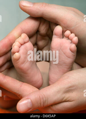 (Dossier) - Un fichier photo dpa en date du 13 décembre 2006 montre une holöding la mère de son bébé pieds de Sieversdorf, Allemagne. Les politiciens allemands marchandent des subventions aux garderies. Photo : Patrick Pleul Banque D'Images