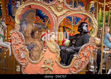 Des gens habillés comme Chewbacca (L) et Dark Vador s'asseoir dans un manège au parc d'attractions Freizeitland Geiselwind Geiselwind, en Allemagne, le 28 juillet 2012. Les membres des clubs de fan de Star Wars à partir de l'ensemble de l'Allemagne apparaît en caractères de la série de films lors d'un défilé au parc d'attractions. Photo : David Ebener Banque D'Images