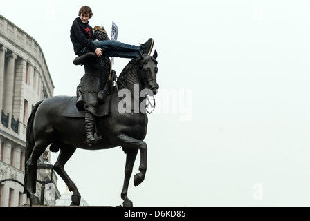 Un manifestant est assis sur la statue de Charles I à Trafalgar Square. Banque D'Images