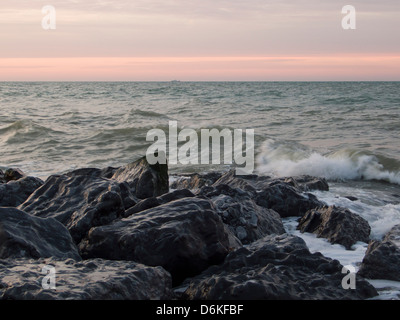 Briser la mer sur des roches, Dawn, Sussex, UK Banque D'Images