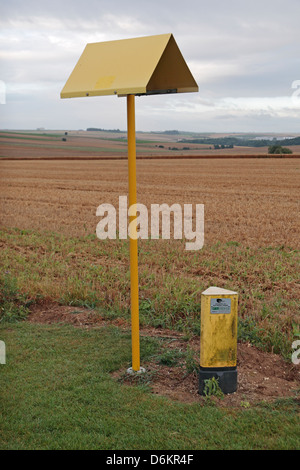 Le marqueur du côté route générique à côté d'un champ dans le nord de la France indiquant des pipelines de gaz naturel souterrain. Banque D'Images