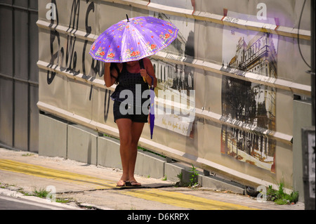 Fille est la protection contre la chaleur par parapluie, Belém, Pará, Brésil Banque D'Images