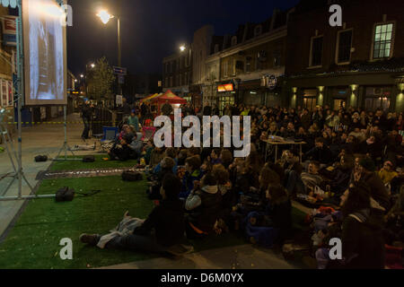 Londres, Royaume-Uni. 19 avril, 2013. Accompagné par un pianiste, au sud de London à siéger en dehors de leur rail station sur le mur est une projection du film muet de Easy Street avec un ancien garçon, Charlie Chaplin, le coup d'une série de la libre Film Festival à Herne Hill dans le quartier londonien de Lambeth. Il n'y a pas de compte rendu officiel de sa naissance bien que Chaplin croyait qu'il était né à East Street dans la ville voisine de Walworth. Richard Baker Crédit / Alamy Live News Banque D'Images