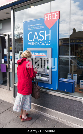 Femme retirer de l'argent de l'ATM à l'échelle nationale Gosforth North East England UK Banque D'Images