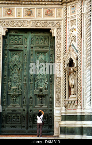 Un touriste prend une photo d'une des portes de la cathédrale de Florence Italie Banque D'Images