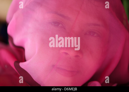 Asian woman face recouverte avec foulard de soie rose, Thaïlande Banque D'Images