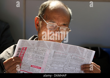 Hong Kong, Chine, Man reading a newspaper Banque D'Images