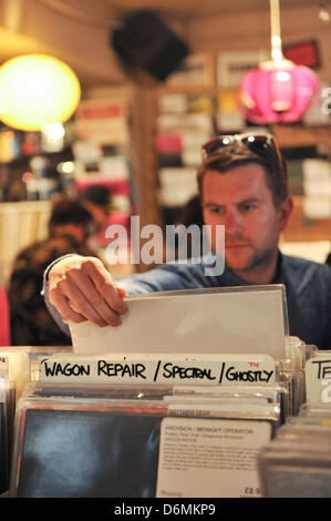 Berwick Street, Soho, London, UK. 20 avril 2013. La navigation à travers 12' LPs dans un magasin de disques indépendants. Record Store Day a été conçu en 2007 lors d'un rassemblement de propriétaires de magasins de disques indépendants et employés comme une façon de célébrer et de faire connaître la culture unique entourant plus de 700 propriétaires de magasins de disques aux États-Unis et des milliers de magasins similaires à l'échelle internationale. Le Royaume-Uni fait de même et 2013 verra la sixième célébration de la UK's unique du secteur indépendant. Banque D'Images