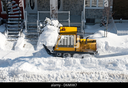 Enlever la neige chasse-neige jaune dans la zone résidentielle de la ville. Banque D'Images