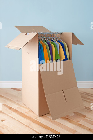 Armoire fort rempli de vêtements colorés, préparé pour le transport. Banque D'Images