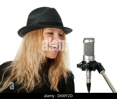 Chanteuse dans le chant black hat avec microphone de studio. Isolé sur fond blanc. Banque D'Images