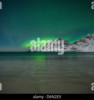 Aurore Boréale - Northern Lights briller dans le ciel au-dessus des montagnes enneigées de la plage de Vik, Vestvågøy, îles Lofoten, Norvège Banque D'Images