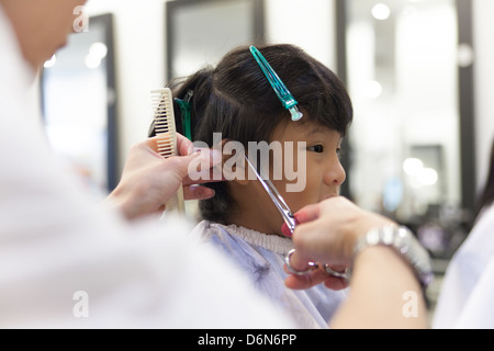 Un jeune garçon se coupe au salon de coiffure Banque D'Images