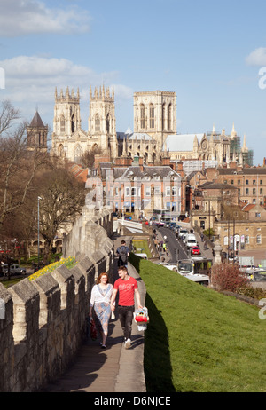 Murs de la ville de York; Les Gens marchant les murs de la vieille ville avec la cathédrale de York Minster en arrière-plan, York, Yorkshire UK Banque D'Images