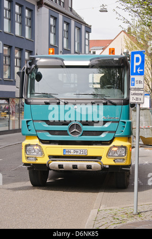 Un livre vert et jaune Mercedes Benz Actros truck parking dans une place de parking - Heilbronn, Allemagne Banque D'Images