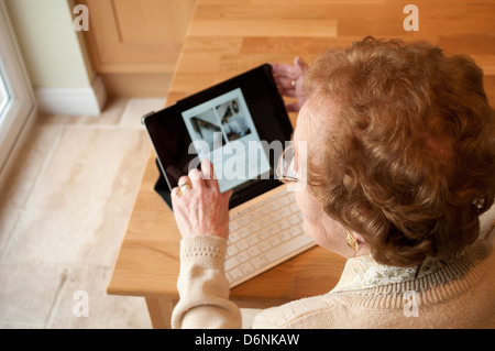 Femme âgée utilise un ordinateur tablette avec clavier sans fil Banque D'Images