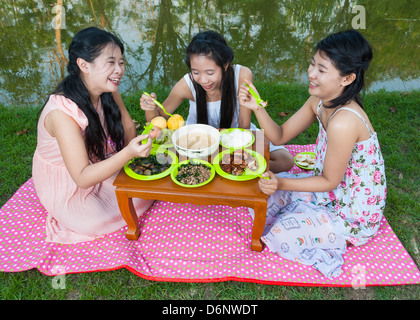 Filles Thai asiatique ensemble pique-nique à côté de marais. Banque D'Images