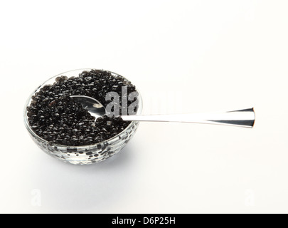 Close-up de cuillère et bol en verre avec black caviar sur le fond blanc Banque D'Images