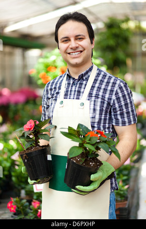 Portrait of a smiling worker holding à effet de pots de fleurs Banque D'Images