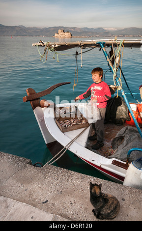 La vente du poisson dans le port de Nauplie, avec l'île de Bourtzi et fort à l'arrière-plan, Argolid, Péloponnèse, Grèce. Banque D'Images