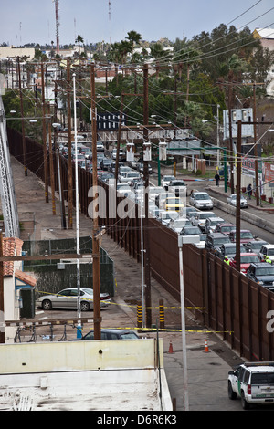 Clôture frontalière et sauvegardé le trafic traversant de Mexicali, Mexique en Calexico, en Californie le 16 février 2012. Banque D'Images